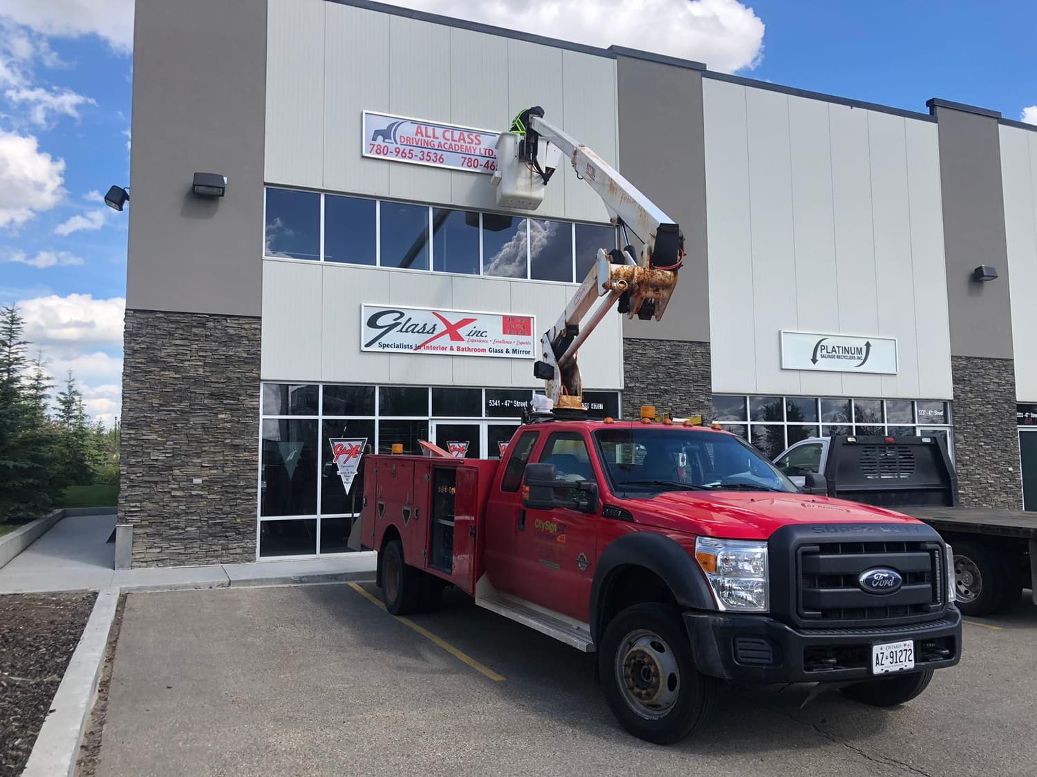 Bucket truck installing signs at Glass X and All Class Driving Academy