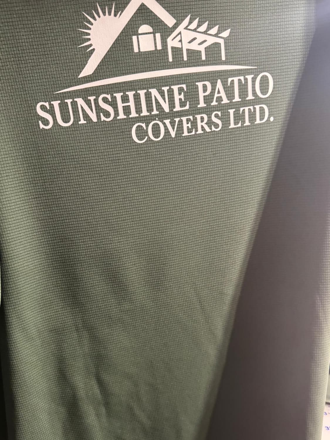 Green shirt with Sunshine Patio Covers logo in white